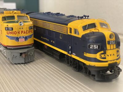 A couple of my model trains sitting on the bleachers at my school.