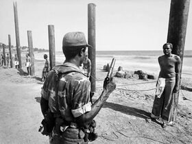 RA soldiers hold MA members on posts, Guajaratuba, 1980.jpeg